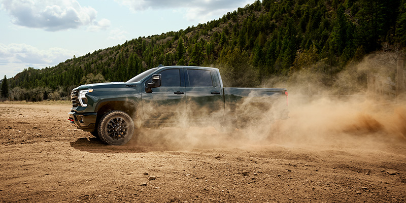 A Chevrolet truck driving through dusty off-road terrain