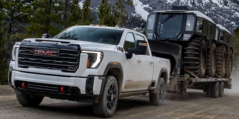 White pickup towing off-road vehicle