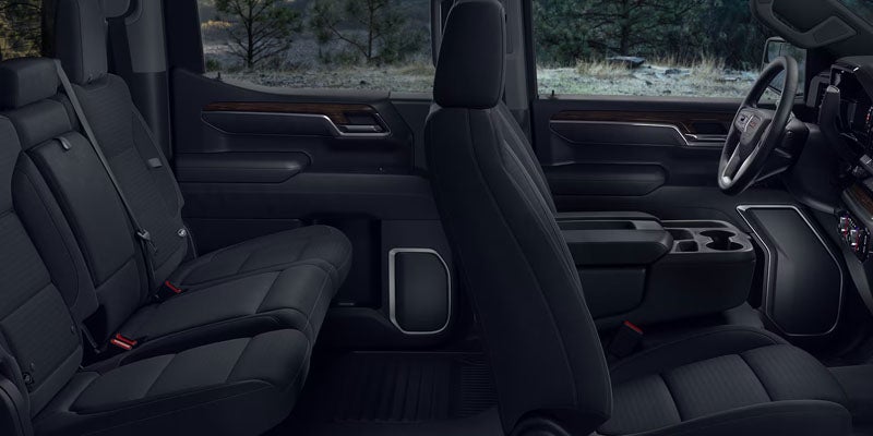 2026 GMC Sierra 1500 interior in Carthage MS showcasing spacious Crew Cab seating, premium materials like leather, wood and aluminum trim, and smart storage for tools and gear